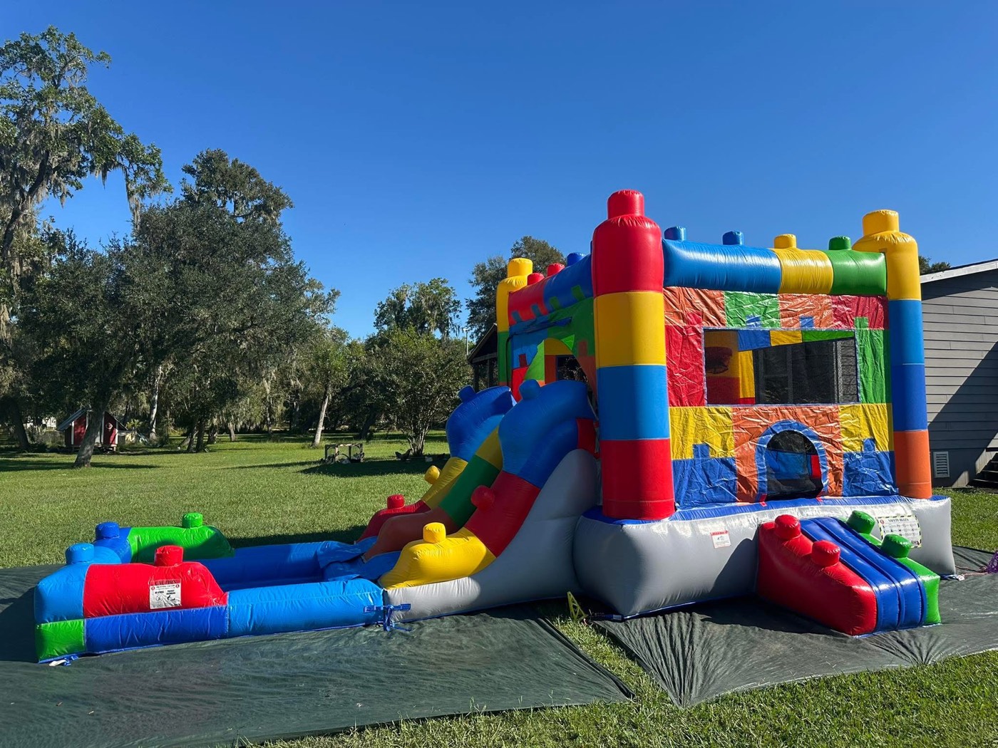Primary color building blocks themed bounce house with slide and splash pool